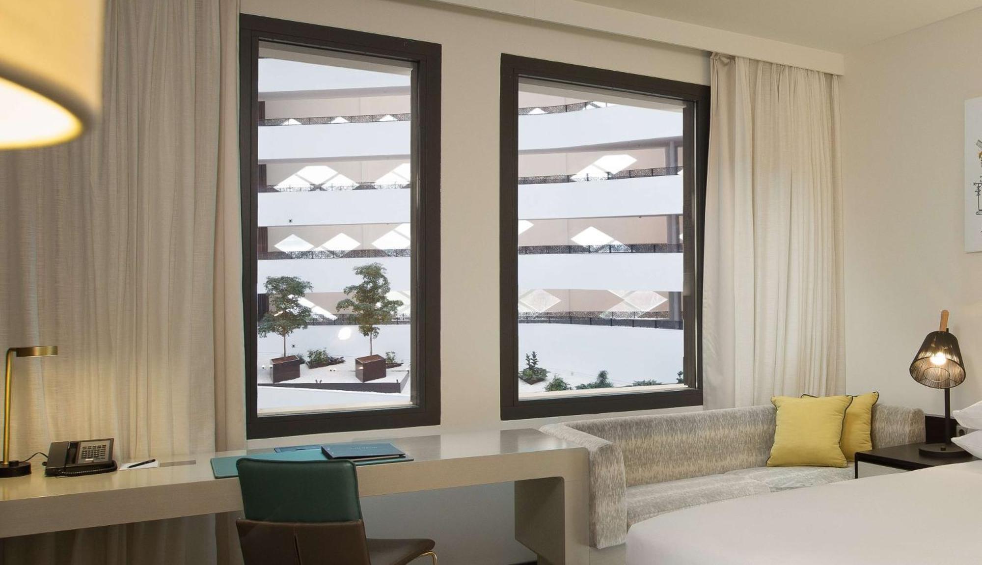 Zimmer mit Kingsize-Bett und Blick auf das Atrium